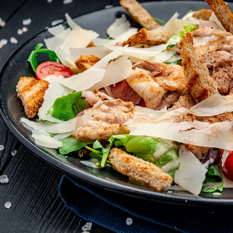 Salade César : poulet grillé, copeaux de parmesan, croûtons et tomates cerises