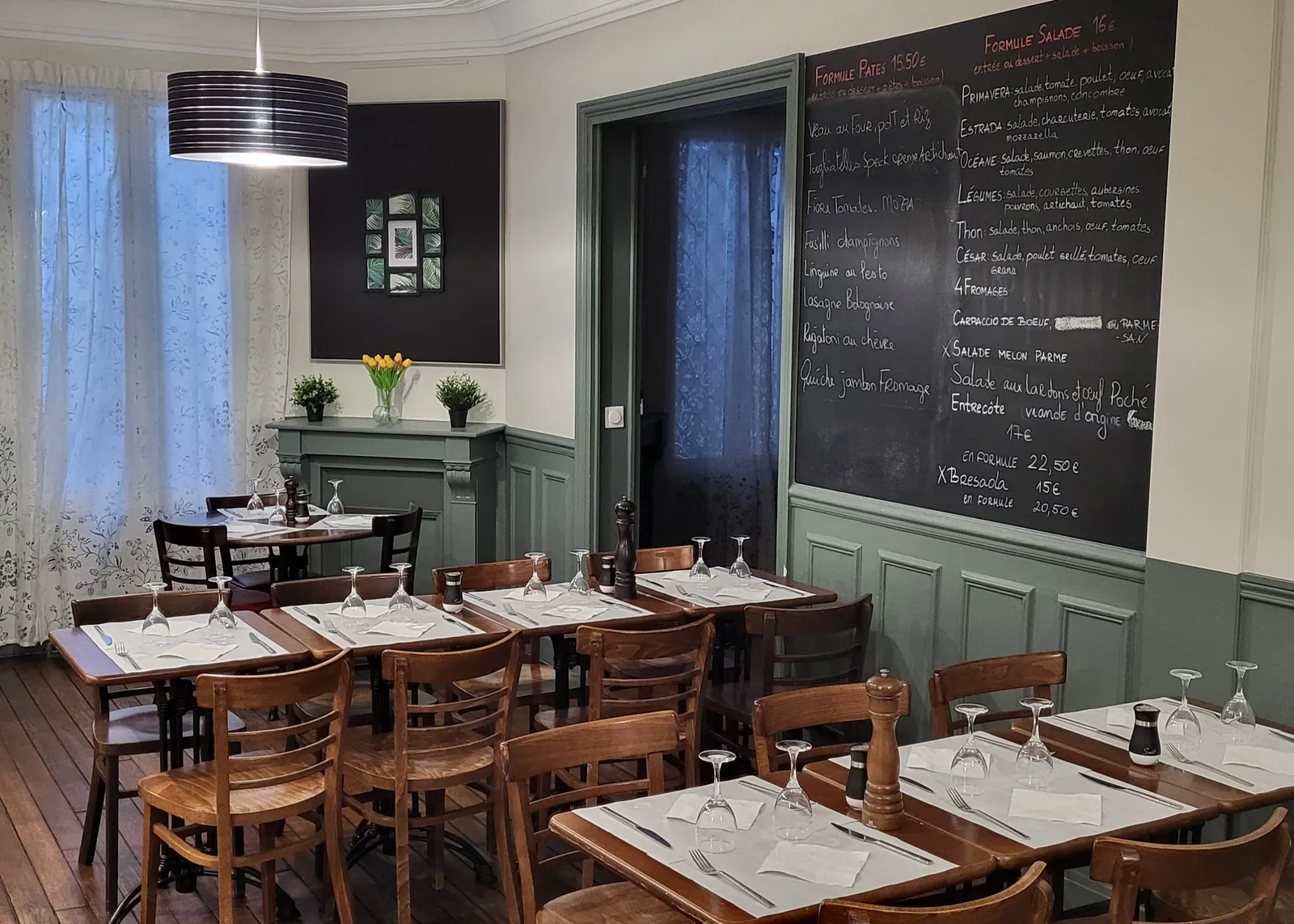 Salle de La Strada : tables en bois, boiseries vert sauge et ardoise des formules du jour